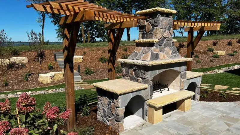 a stone fireplace with a pergola